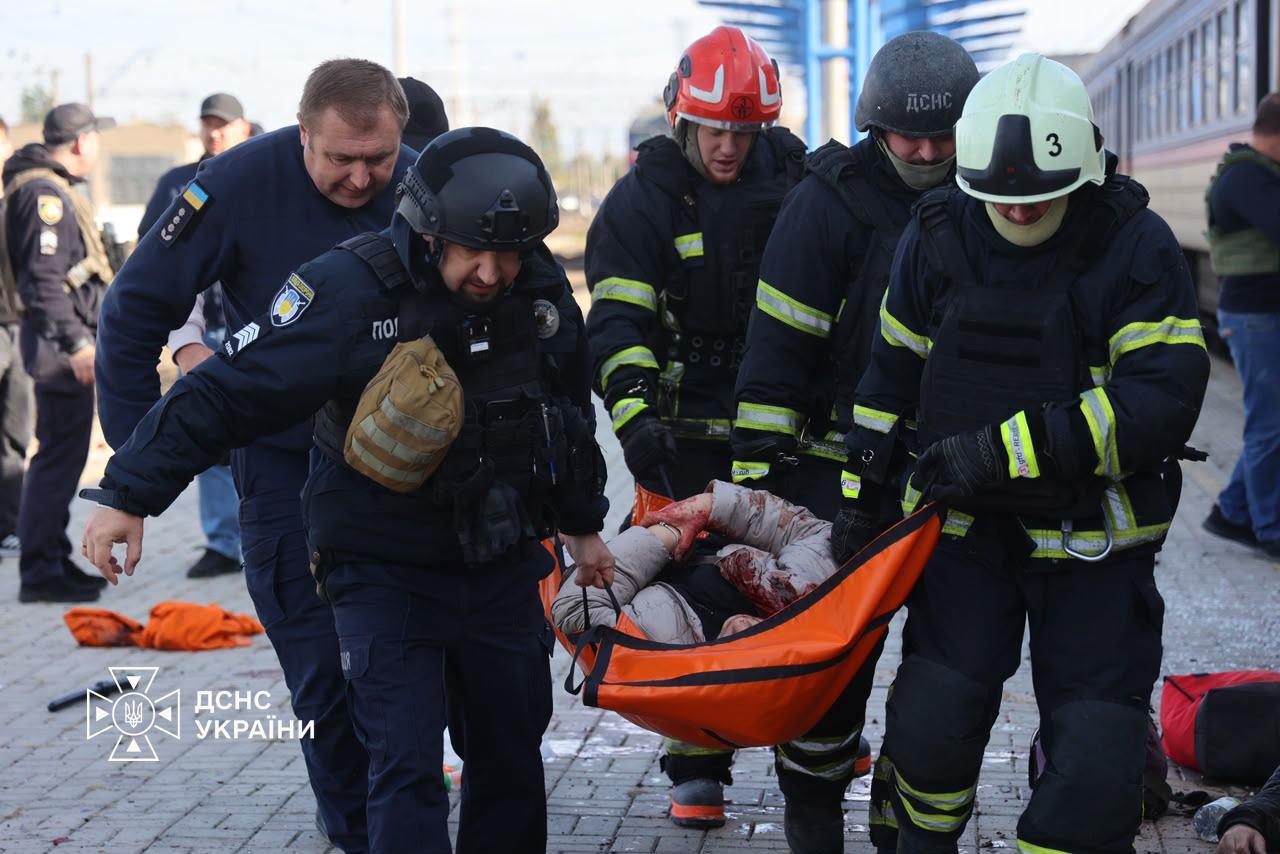 Rescue workers carry an injured passenger along the platform at Dnipro railway station